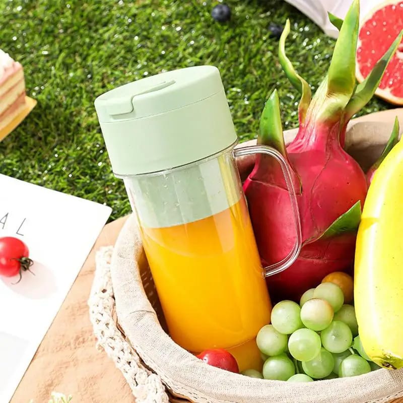 Portable juicer blender cup with mint lid and yellow juice in clear container